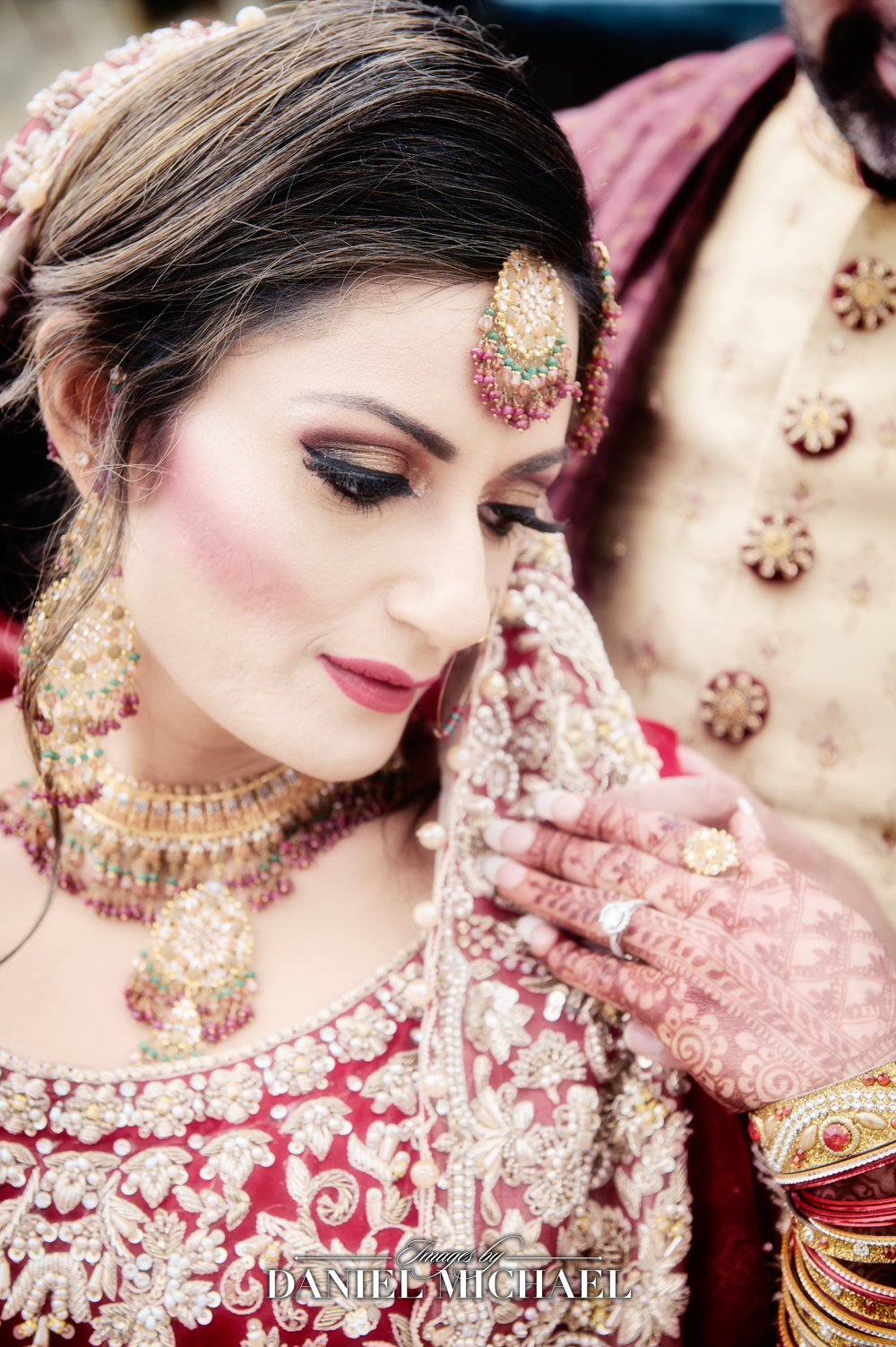 Elegant South Asian Muslim bride and groom dressed in traditional wedding outfits, with intricate gold jewelry and henna designs